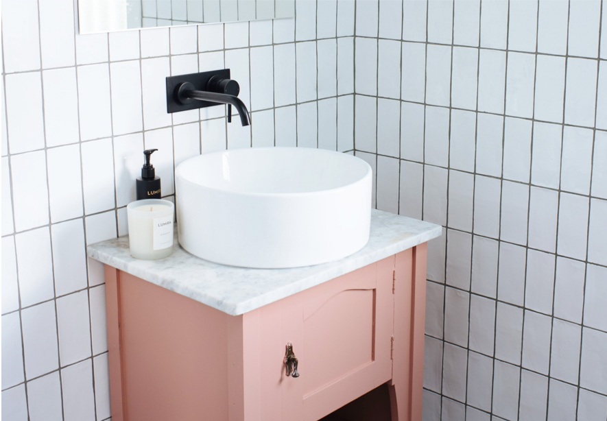 Muebles en tono rosa pastel con complementos modernos para un baño más actual y elegante